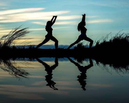 Person doing yoga outdoors at sunrise