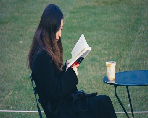 Woman reading a book with a cup of tea